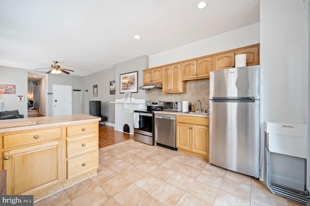 kitchen with appliances with stainless steel finishes, ceiling fan, decorative backsplash, and light tile patterned floors