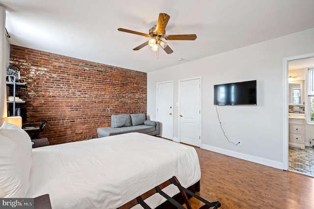 unfurnished bedroom with ceiling fan, wood-type flooring, and brick wall