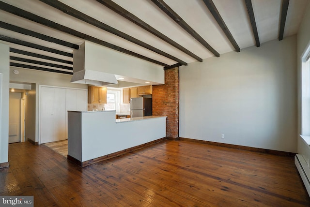 kitchen with wood-type flooring, stainless steel refrigerator, beam ceiling, kitchen peninsula, and a baseboard heating unit