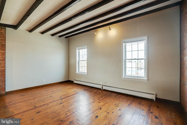 unfurnished room with baseboards, baseboard heating, beam ceiling, and wood finished floors