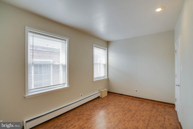 spare room with hardwood / wood-style flooring and a baseboard radiator