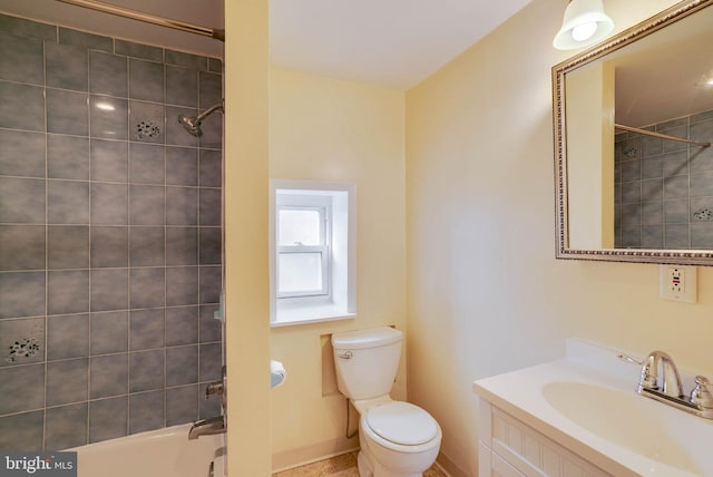 full bathroom with tiled shower / bath, vanity, and toilet