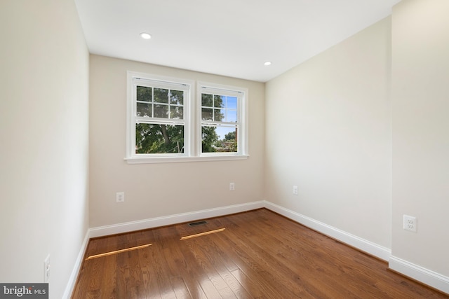 empty room with visible vents, baseboards, dark wood-style flooring, and recessed lighting