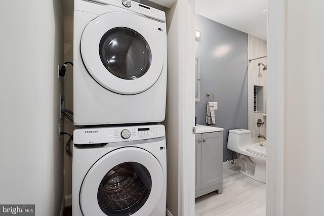 laundry room featuring stacked washing maching and dryer and light tile patterned floors