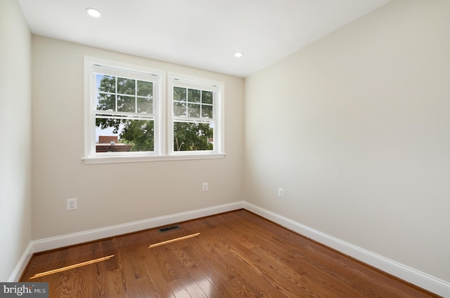 empty room with recessed lighting, wood finished floors, and baseboards