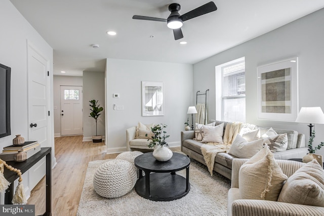 living room with light hardwood / wood-style flooring and ceiling fan