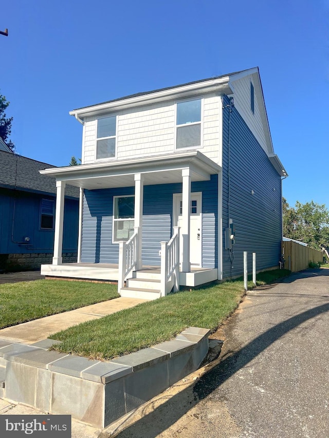 view of front property featuring a front lawn and covered porch