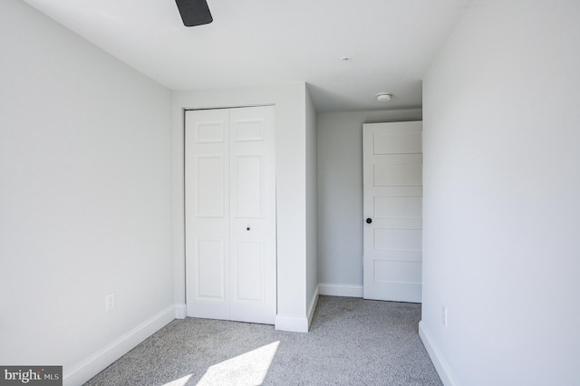 unfurnished bedroom with light colored carpet, ceiling fan, and a closet