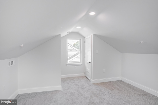 bonus room featuring light colored carpet and vaulted ceiling