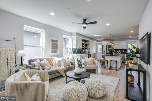 living room featuring light hardwood / wood-style flooring and ceiling fan