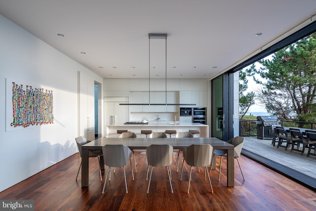 dining area with dark wood-style floors and a wall of windows