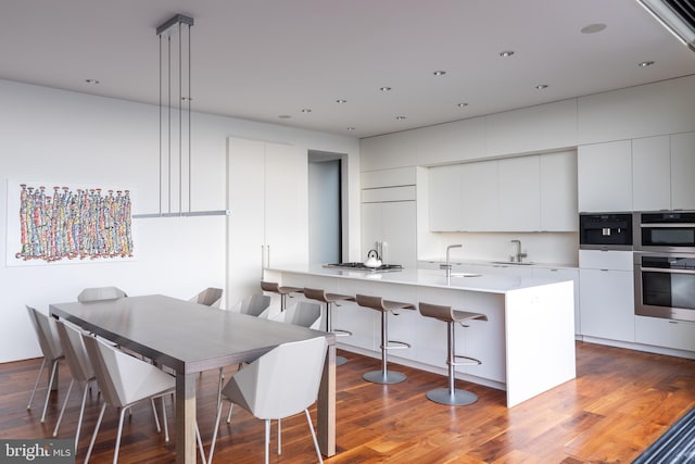 kitchen with modern cabinets, white cabinets, and wood finished floors