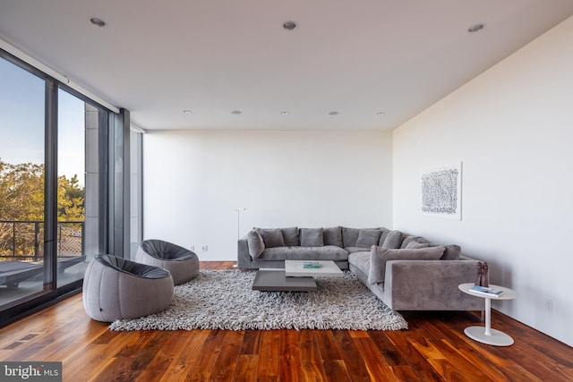 living area with expansive windows, wood finished floors, and visible vents