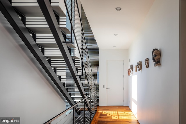 corridor with light wood-type flooring, stairs, and recessed lighting