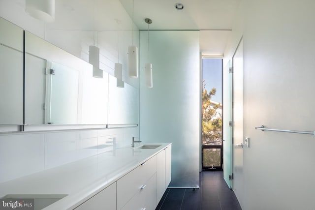 bathroom featuring a wall of windows, a sink, backsplash, and double vanity