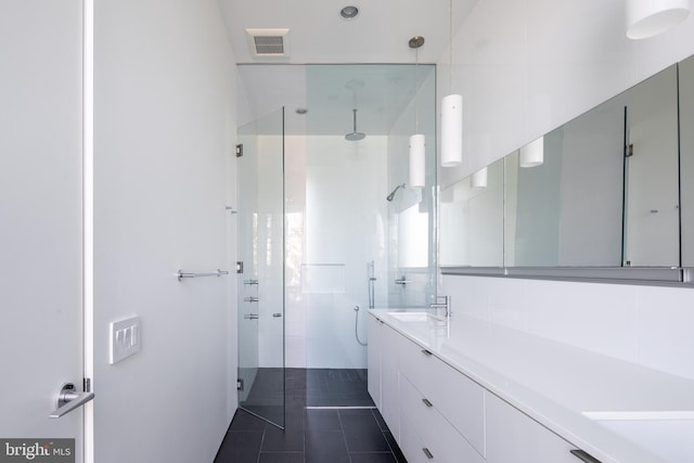 bathroom with a stall shower, vanity, visible vents, and tile patterned floors