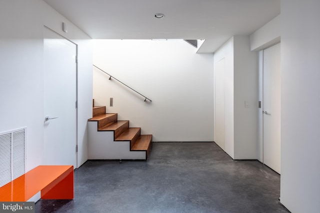 stairs featuring concrete flooring and visible vents