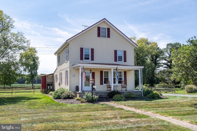 view of property featuring a porch and a front yard