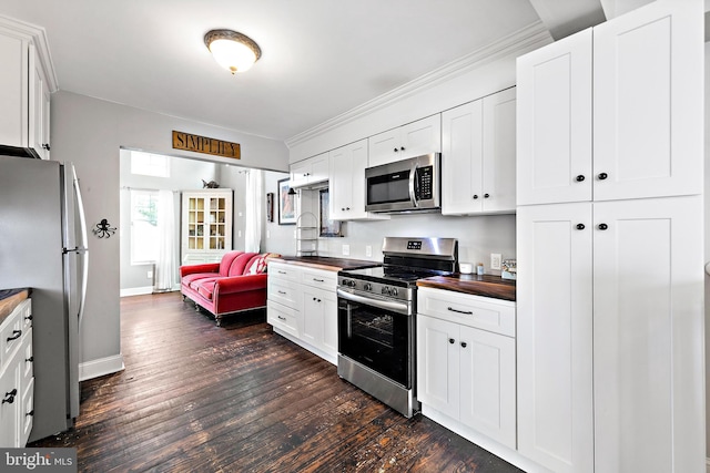 kitchen with white cabinetry, butcher block counters, stainless steel appliances, and dark hardwood / wood-style flooring