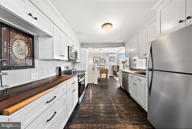 kitchen featuring dark hardwood / wood-style flooring, white cabinets, and appliances with stainless steel finishes