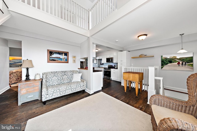 living room with dark hardwood / wood-style floors and a towering ceiling