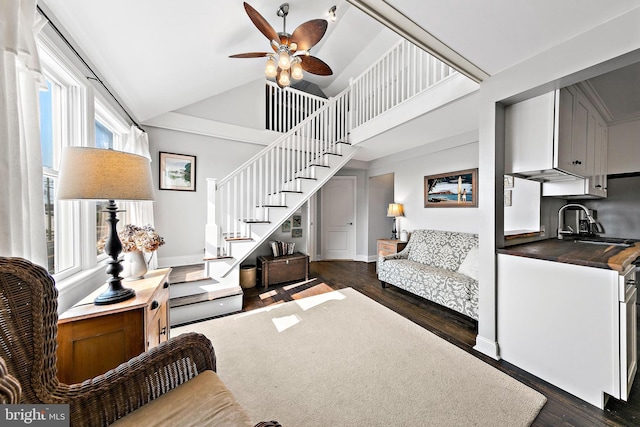 living room featuring ceiling fan, high vaulted ceiling, and dark wood-type flooring