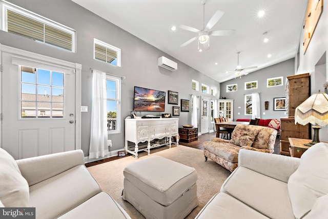 living room featuring hardwood / wood-style flooring, high vaulted ceiling, a wall mounted AC, and ceiling fan