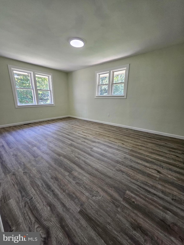 unfurnished room featuring dark hardwood / wood-style floors and plenty of natural light