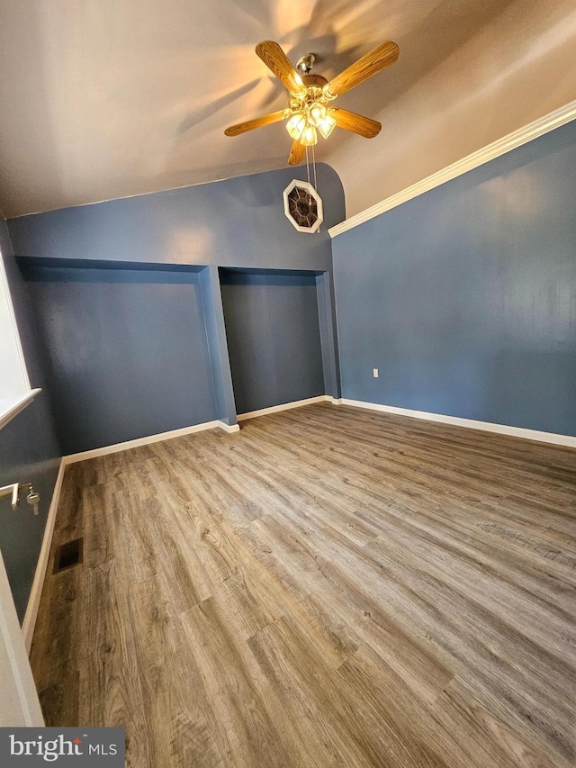 spare room with hardwood / wood-style flooring, vaulted ceiling, and ceiling fan