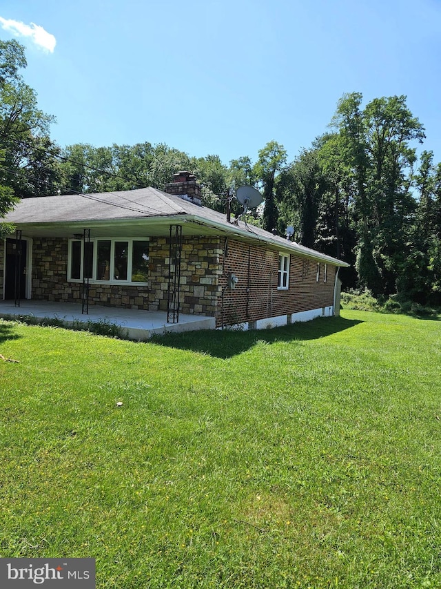 view of home's exterior featuring a patio area and a lawn