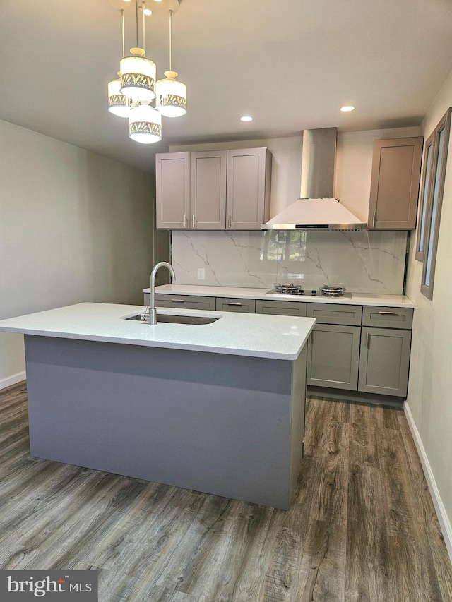 kitchen featuring wall chimney range hood, decorative backsplash, sink, and dark hardwood / wood-style flooring