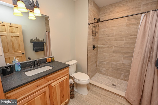 full bath with tiled shower, vanity, and toilet