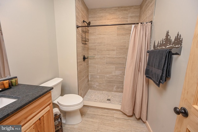 full bath featuring a stall shower, vanity, and toilet