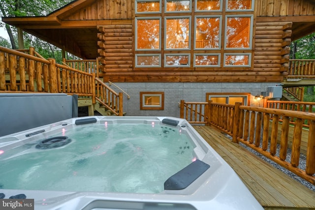 deck featuring a hot tub and stairway