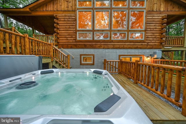 wooden deck featuring an indoor hot tub and stairway