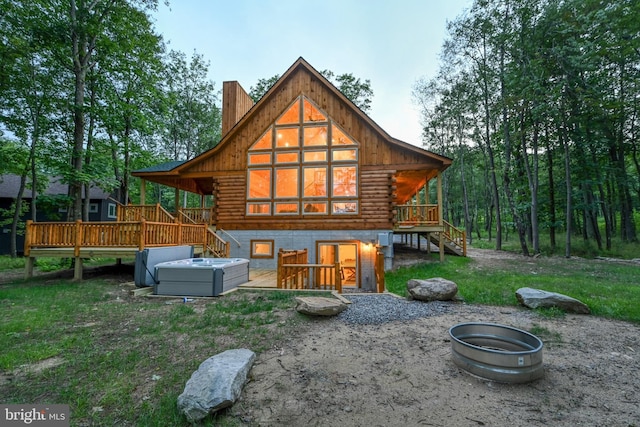 rear view of property featuring stairs, log exterior, a chimney, and a wooden deck