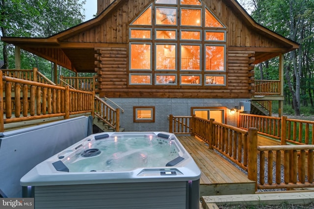 wooden deck with a hot tub and stairway