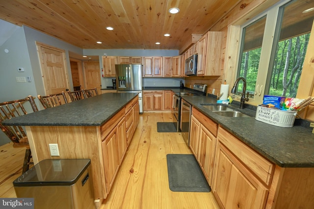 kitchen featuring stainless steel appliances, a sink, a kitchen island, wood ceiling, and dark countertops