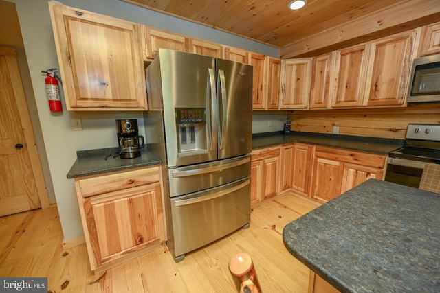 kitchen featuring wooden ceiling, stainless steel appliances, dark countertops, and light wood-style flooring