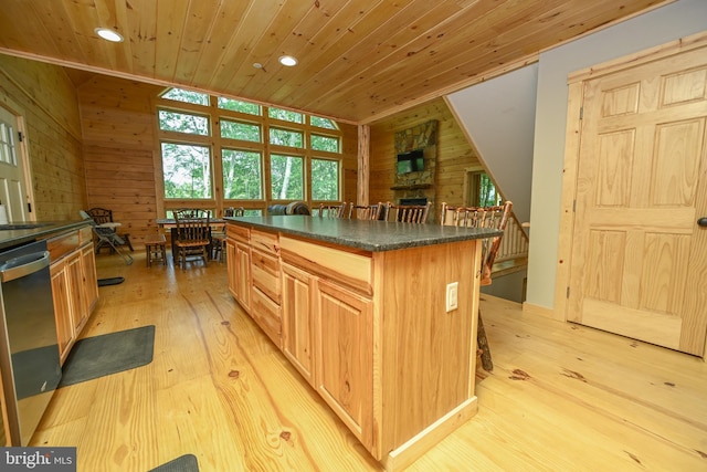 kitchen with dishwasher, dark countertops, wooden ceiling, a center island, and wood walls