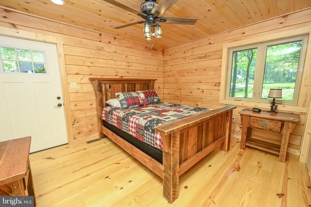 bedroom featuring light wood-type flooring, wood ceiling, and wooden walls