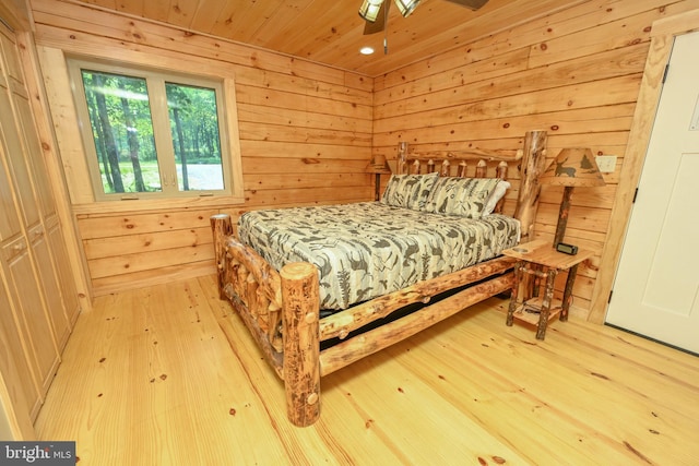 bedroom with wooden ceiling, light wood-style flooring, and wooden walls