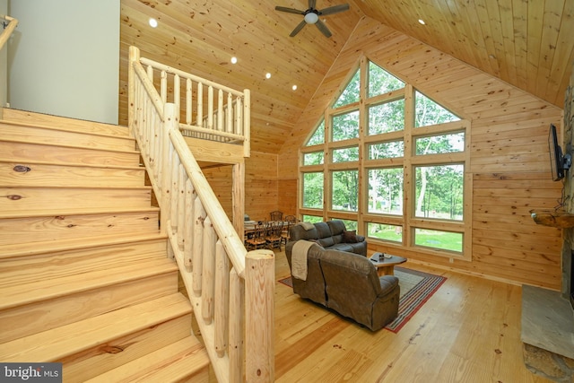 living area featuring wood ceiling, wooden walls, high vaulted ceiling, and wood finished floors