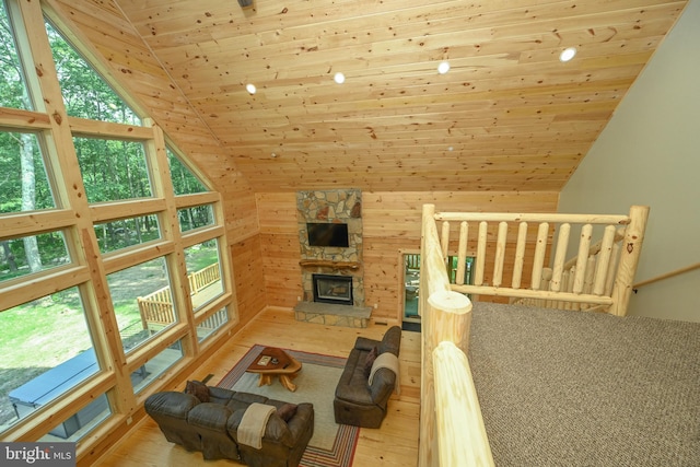 living room with wooden ceiling, a healthy amount of sunlight, a fireplace, and light wood-style flooring