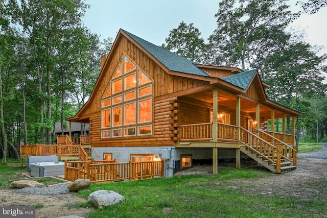 rear view of house with board and batten siding, roof with shingles, stairway, and log siding