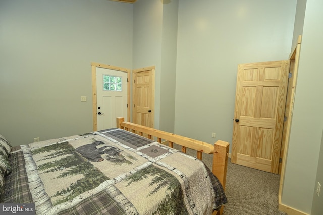 carpeted bedroom featuring a high ceiling