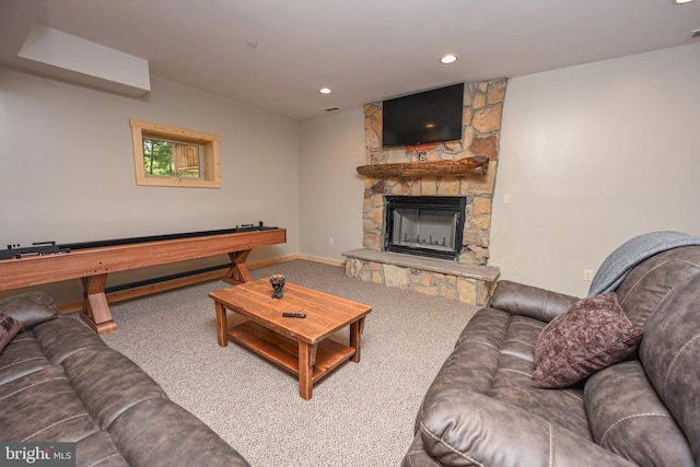 living room featuring baseboards, carpet floors, a stone fireplace, and recessed lighting