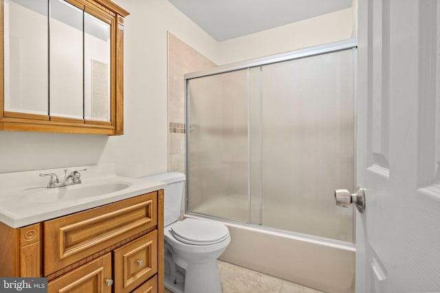 full bathroom featuring shower / bath combination with glass door, toilet, vanity, and tile patterned flooring