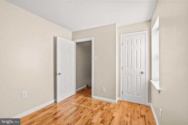 unfurnished bedroom featuring light hardwood / wood-style flooring and a closet