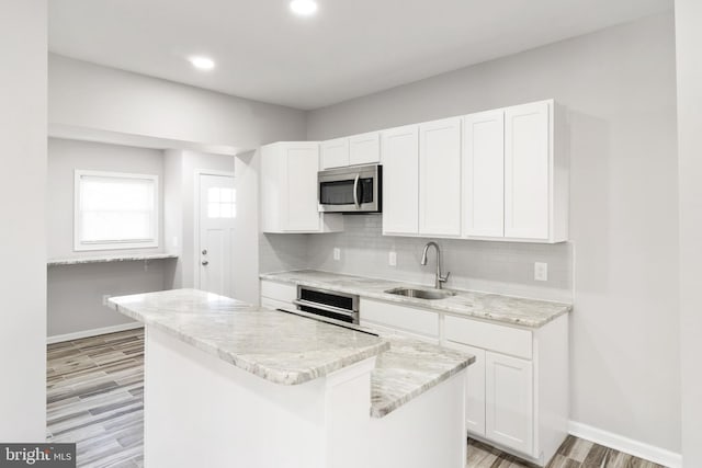 kitchen featuring white cabinetry, appliances with stainless steel finishes, a center island, and backsplash